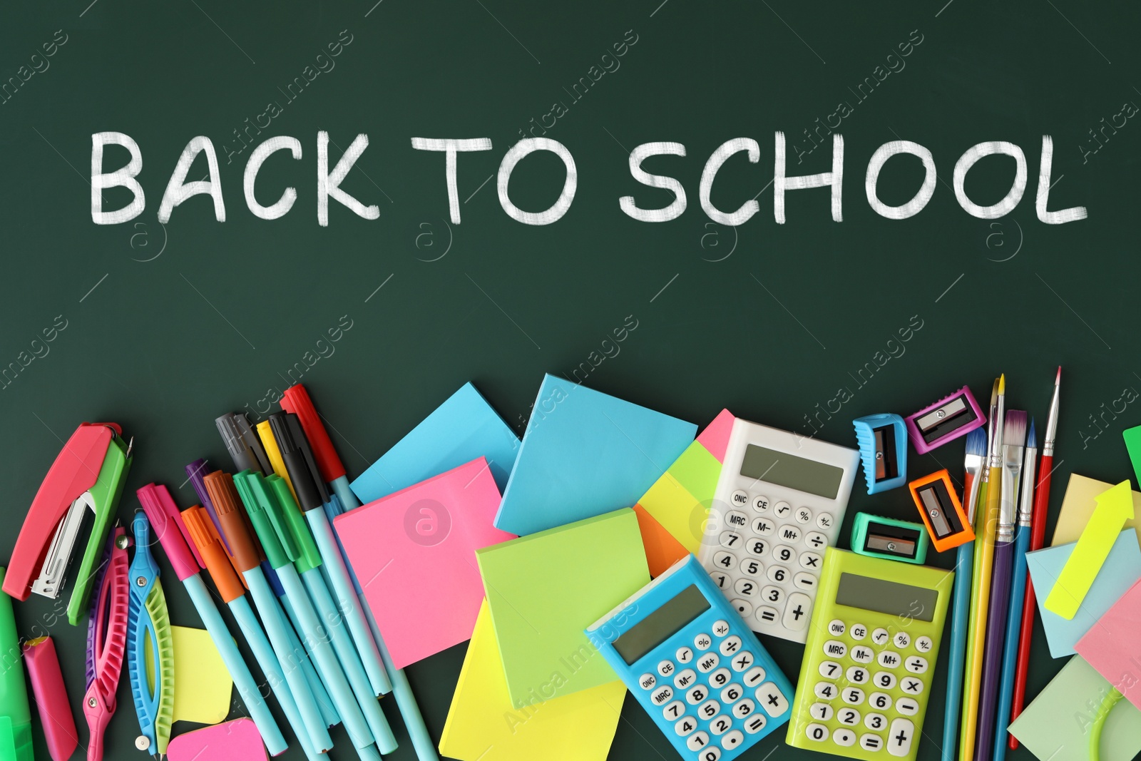 Image of Text Back To School and different stationery on green chalkboard, flat lay