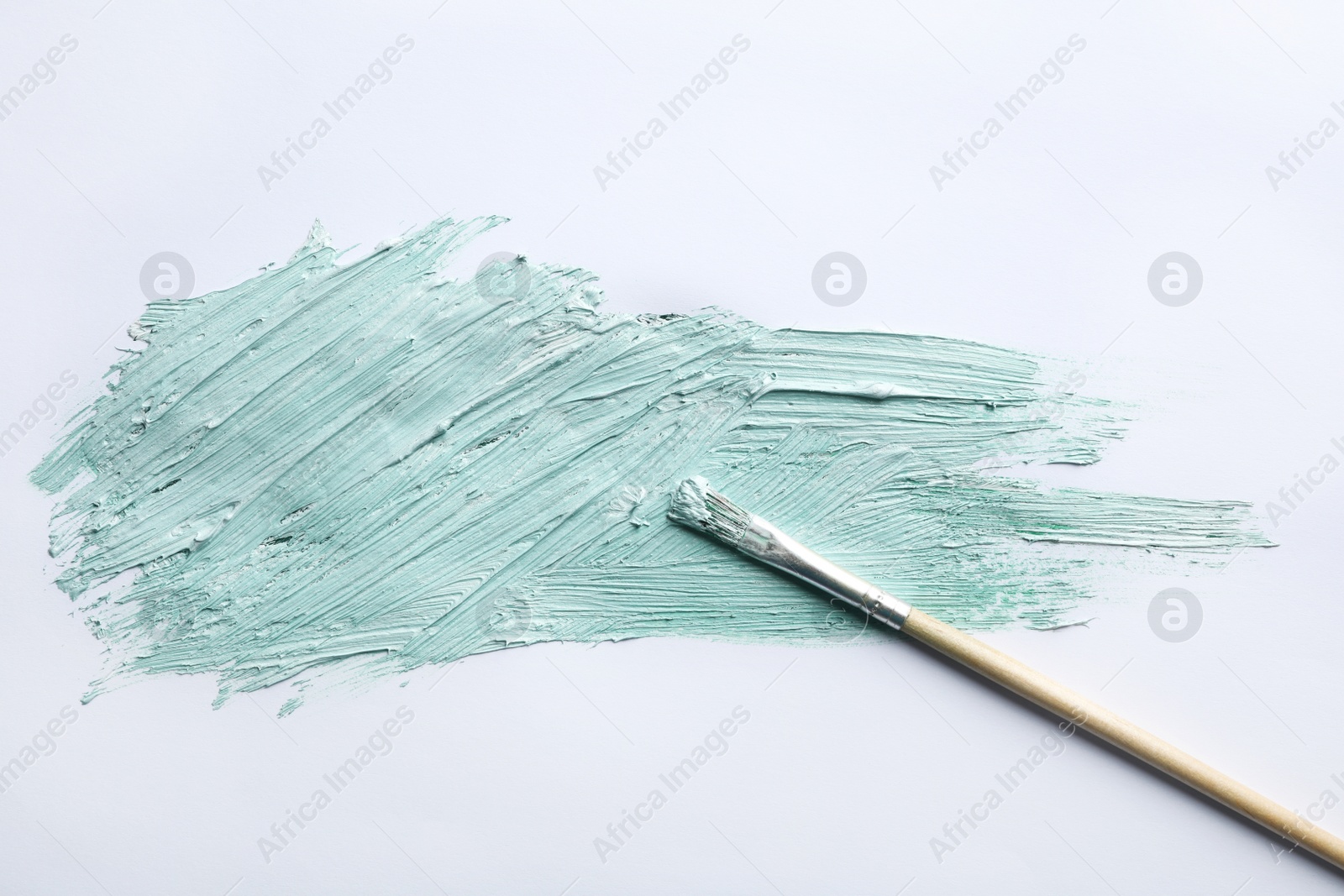 Photo of Paint stroke and brush on white background, top view
