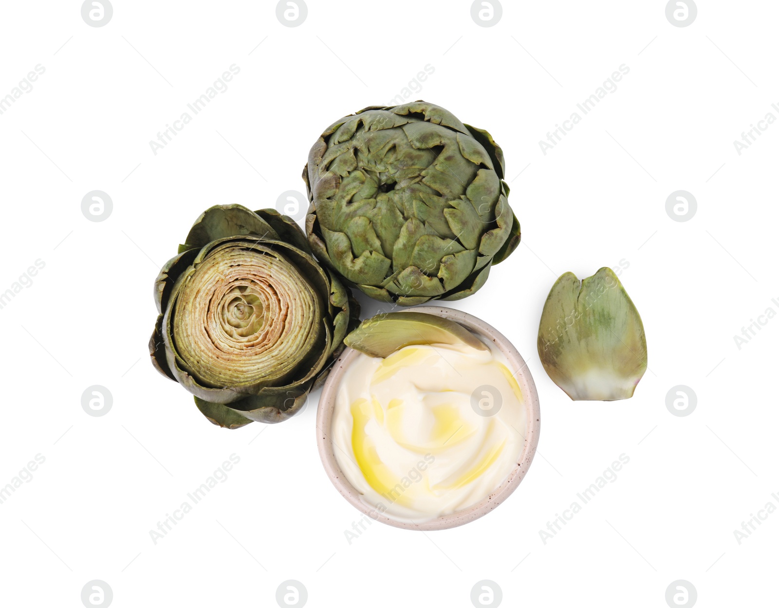 Photo of Delicious cooked artichokes with tasty sauce isolated on white, top view
