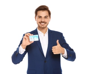 Happy young businessman with driving license on white background