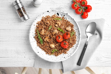 Photo of Flat lay composition with tasty buckwheat porridge on white wooden table