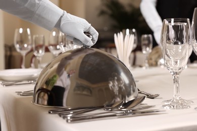 Woman setting table in restaurant, closeup. Professional butler courses