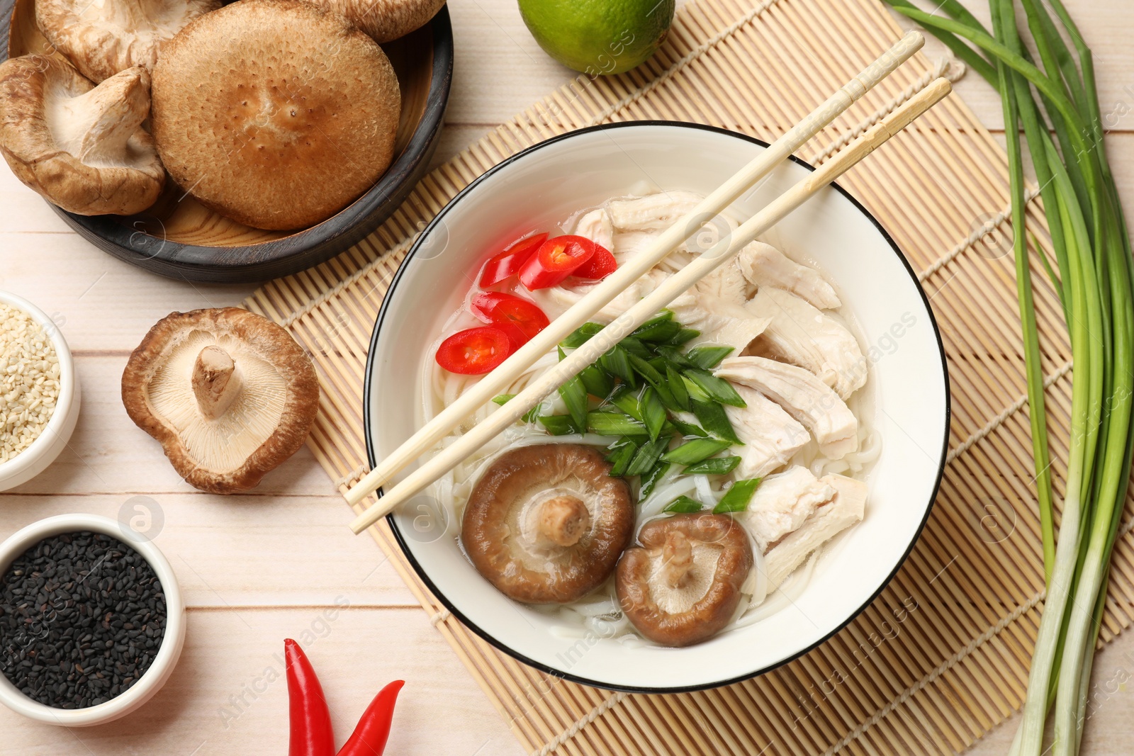 Photo of Delicious ramen with meat and ingredients on wooden table, flat lay. Noodle soup