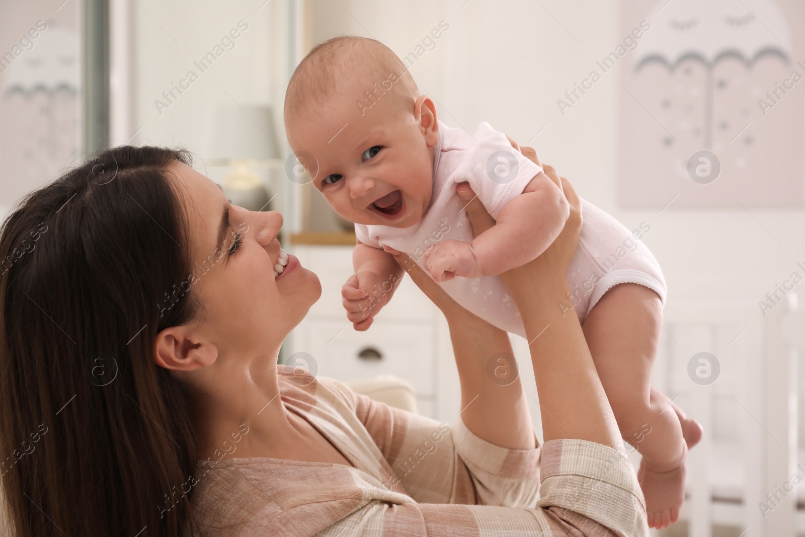 Photo of Happy young mother with her cute baby at home