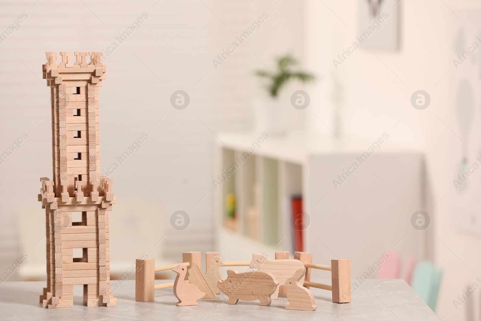 Photo of Wooden tower, animals and fence on table indoors, space for text. Children's toys