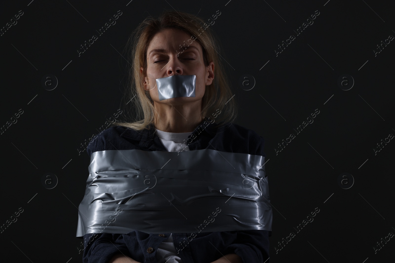 Photo of Woman taped up and taken hostage on dark background