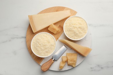 Photo of Composition with whole and grated parmesan cheese on white marble table, top view