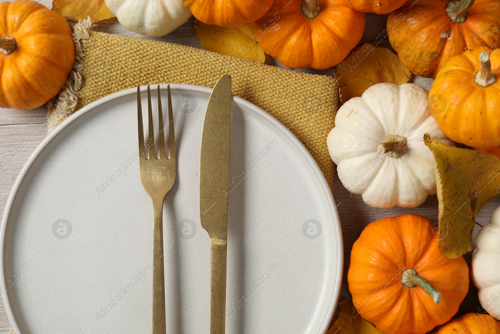 Photo of Happy Thanksgiving day. Beautiful table setting, autumn leaves and pumpkins, flat lay