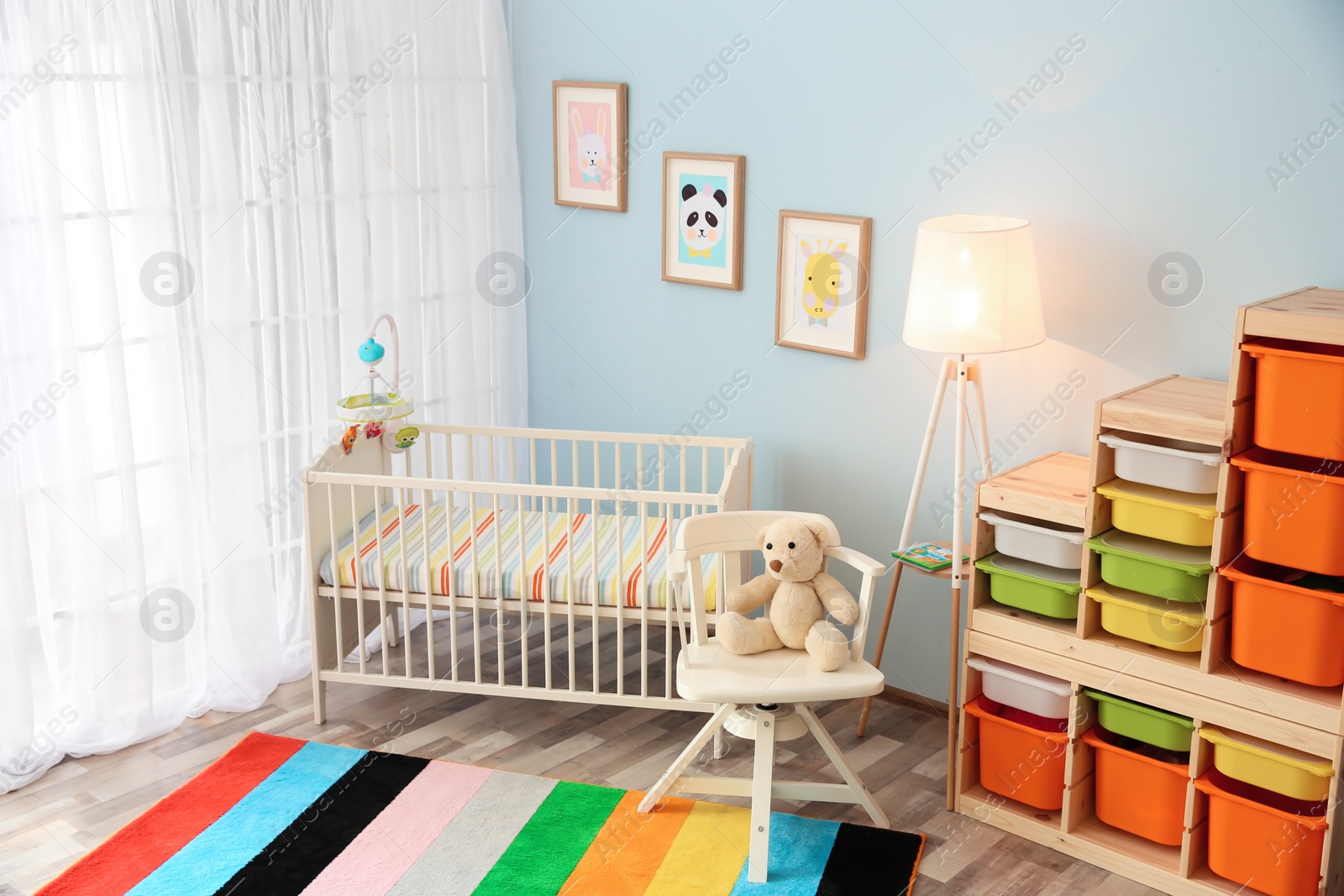 Photo of Modern interior of light cozy baby room with crib