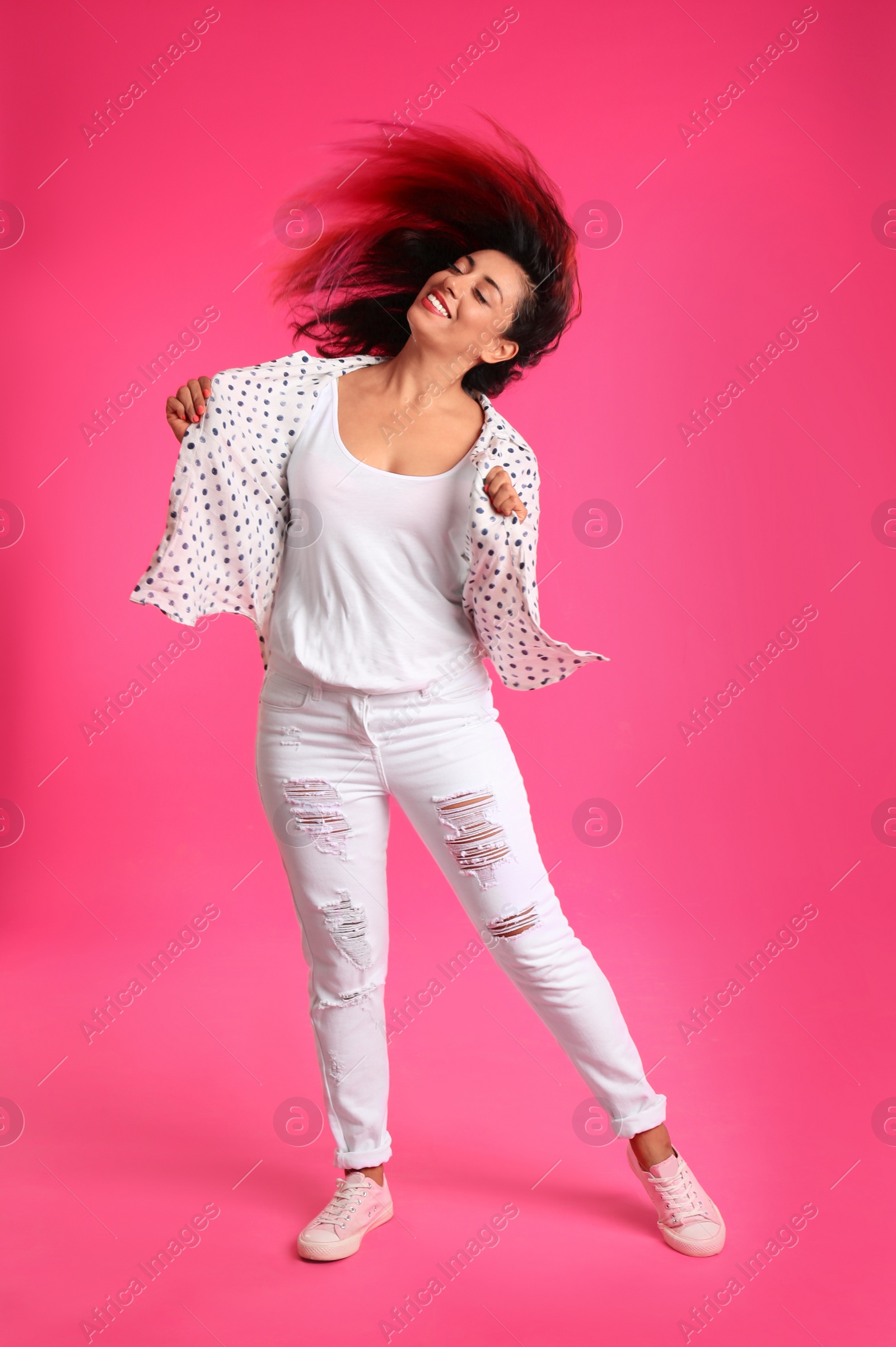 Photo of Beautiful Hispanic woman dancing on pink background