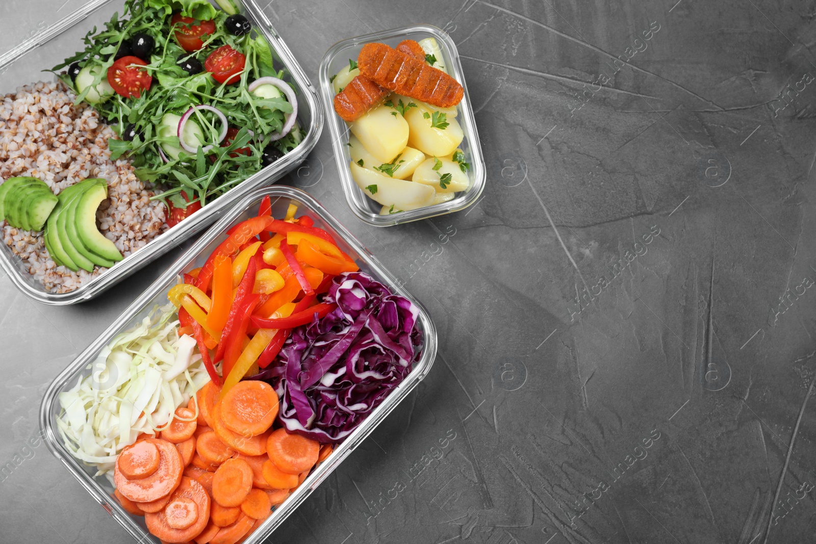 Photo of Set of glass containers with fresh food on grey table, flat lay. Space for text