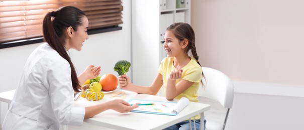 Image of Little girl visiting professional nutritionist in office. Banner design