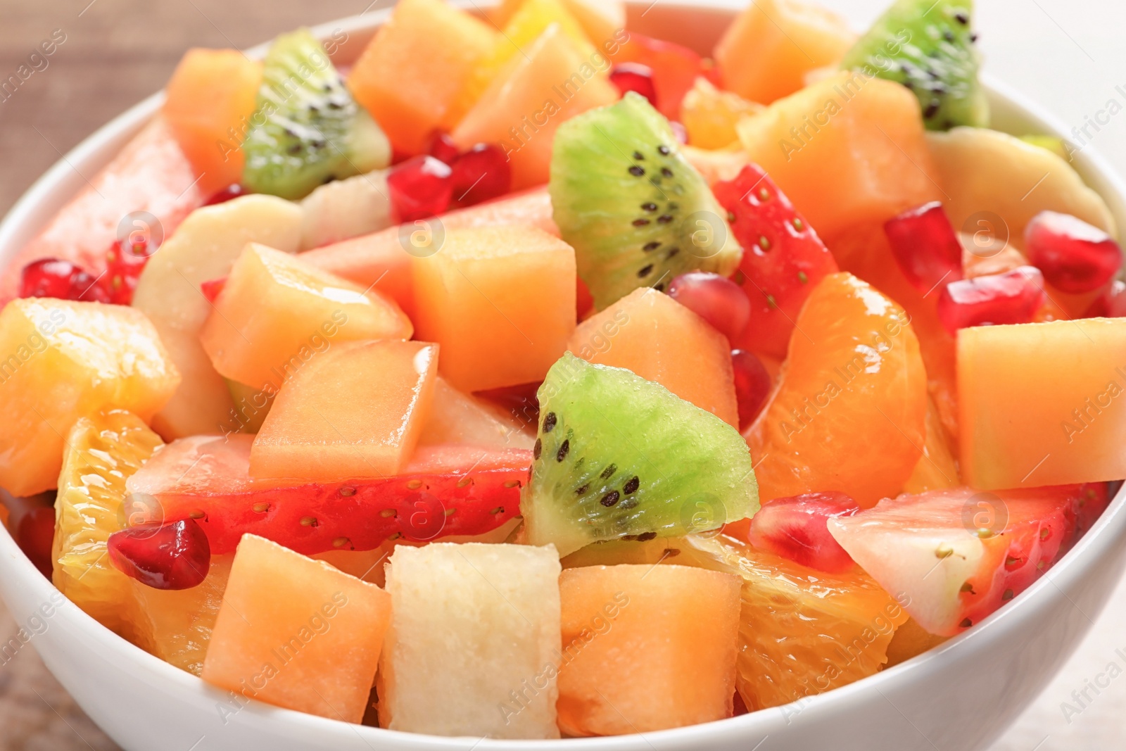 Photo of Bowl with fresh cut fruits, closeup