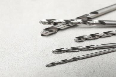 Different drill bits on light table, closeup. Space for text