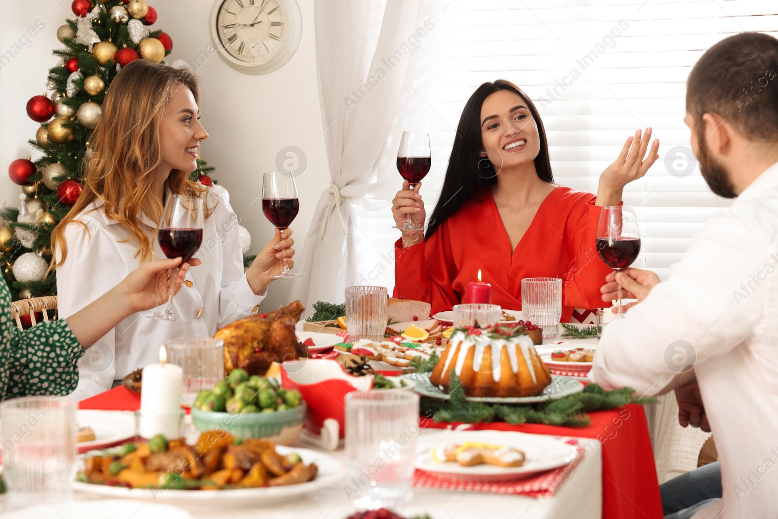 Photo of Happy family with their friends enjoying festive dinner at home. Christmas Eve celebration