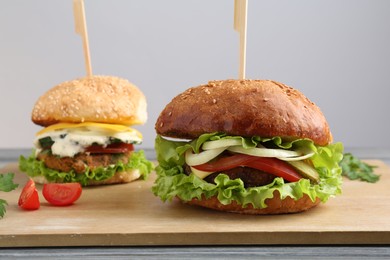 Photo of Delicious vegetarian burgers served on grey wooden table