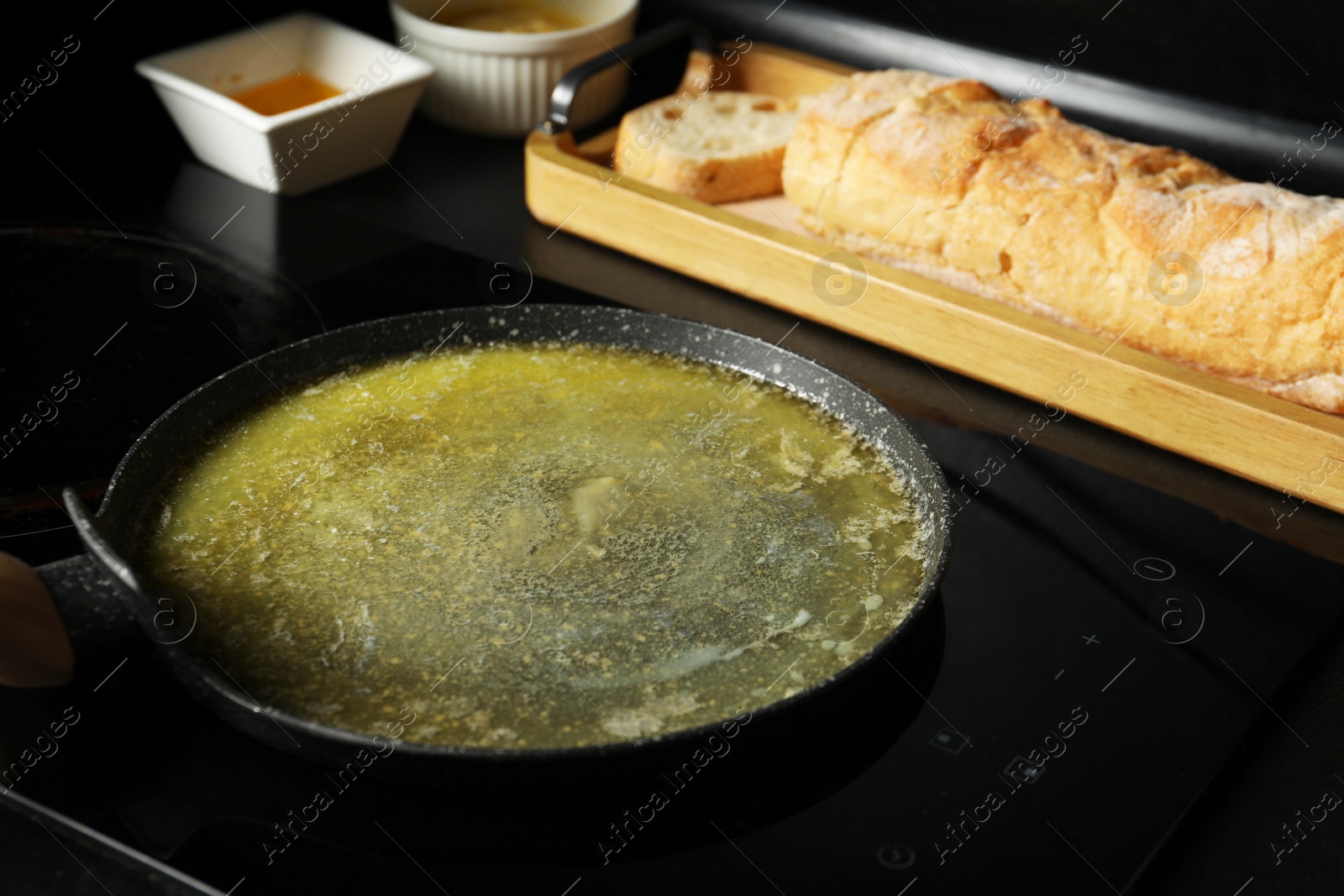 Photo of Melted butter in frying pan on cooktop