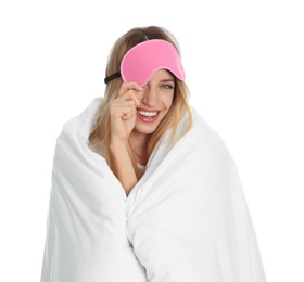 Photo of Young woman in sleeping mask wrapped with soft blanket on white background