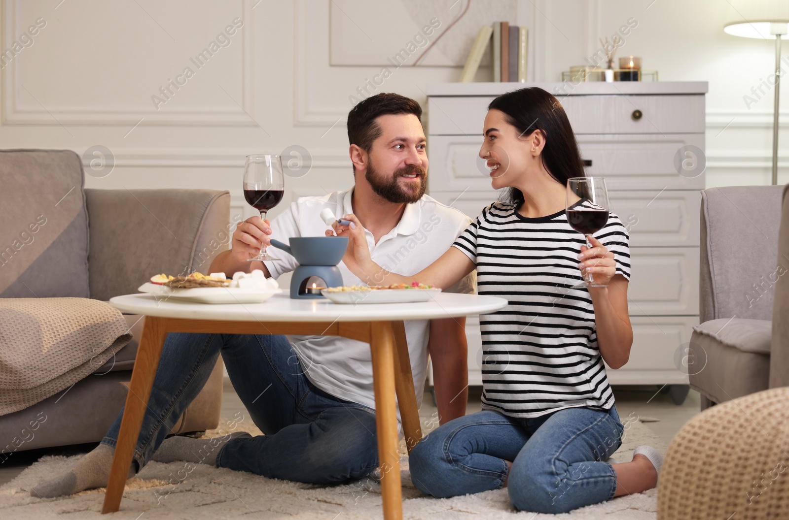 Photo of Affectionate couple enjoying fondue during romantic date at home