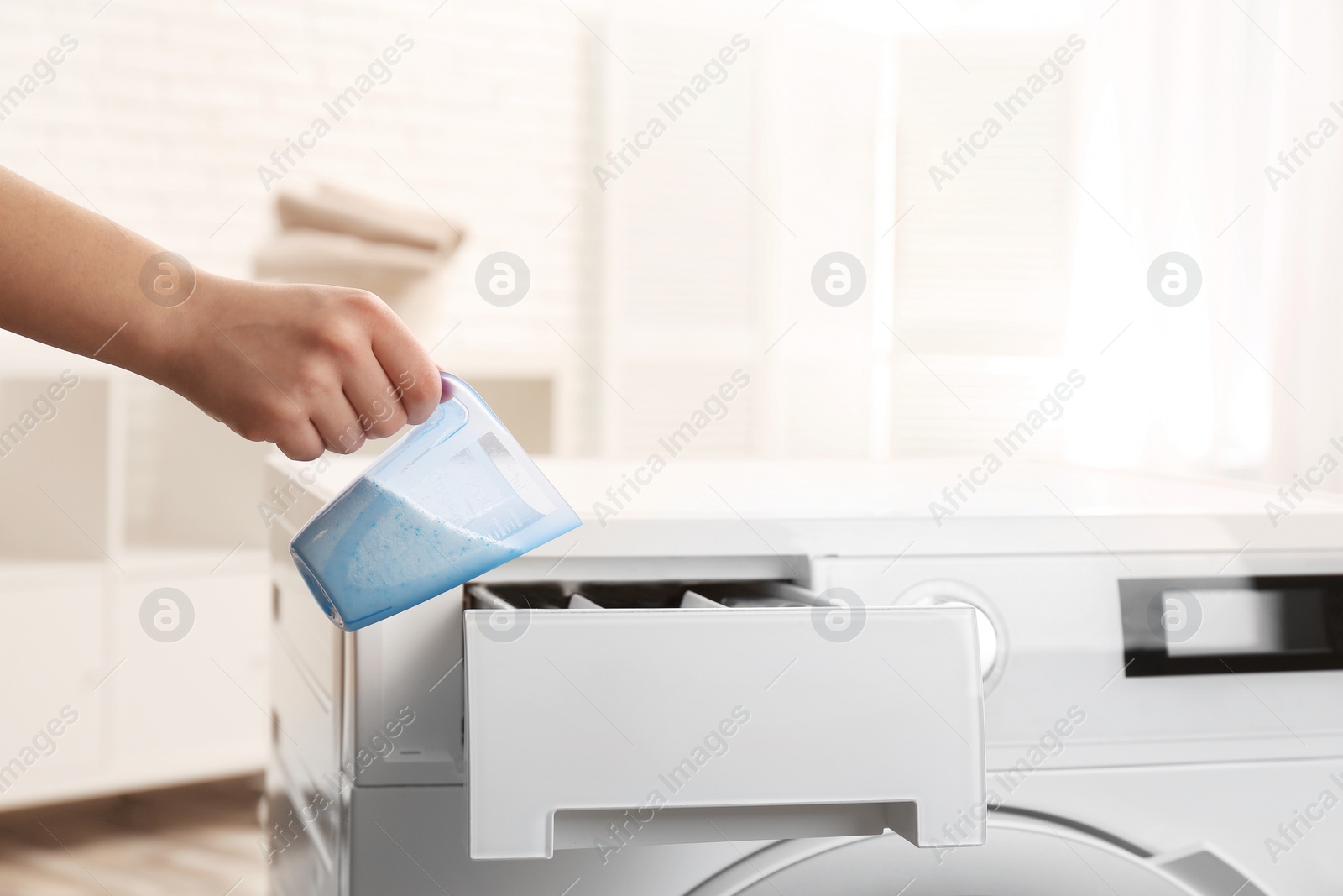 Photo of Woman pouring powder into drawer of washing machine indoors, closeup with space for text. Laundry day