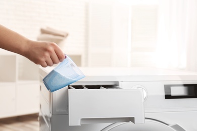 Photo of Woman pouring powder into drawer of washing machine indoors, closeup with space for text. Laundry day