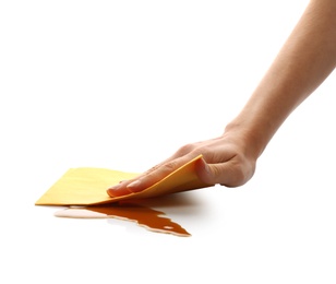 Photo of Woman wiping spilled coffee with paper napkin on white background, closeup