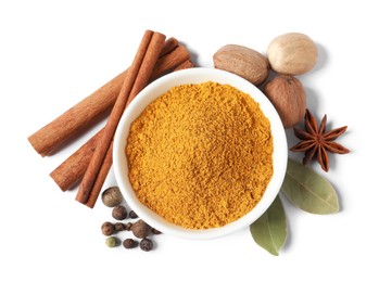 Photo of Dry curry powder in bowl surrounded by other spices isolated on white, top view