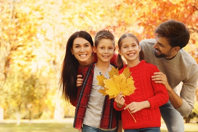 Photo of Happy family with children spending time in park. Autumn walk