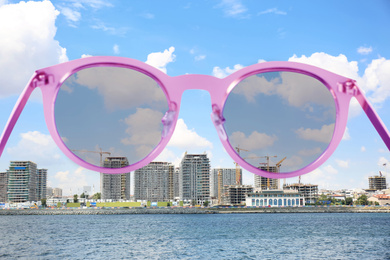 Beautiful city on sea shore, view through sunglasses