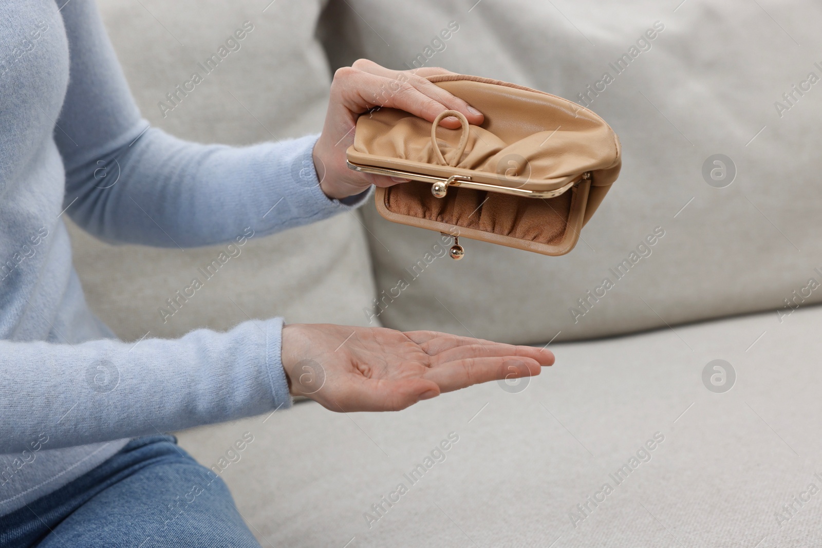 Photo of Woman with empty wallet on sofa indoors, closeup