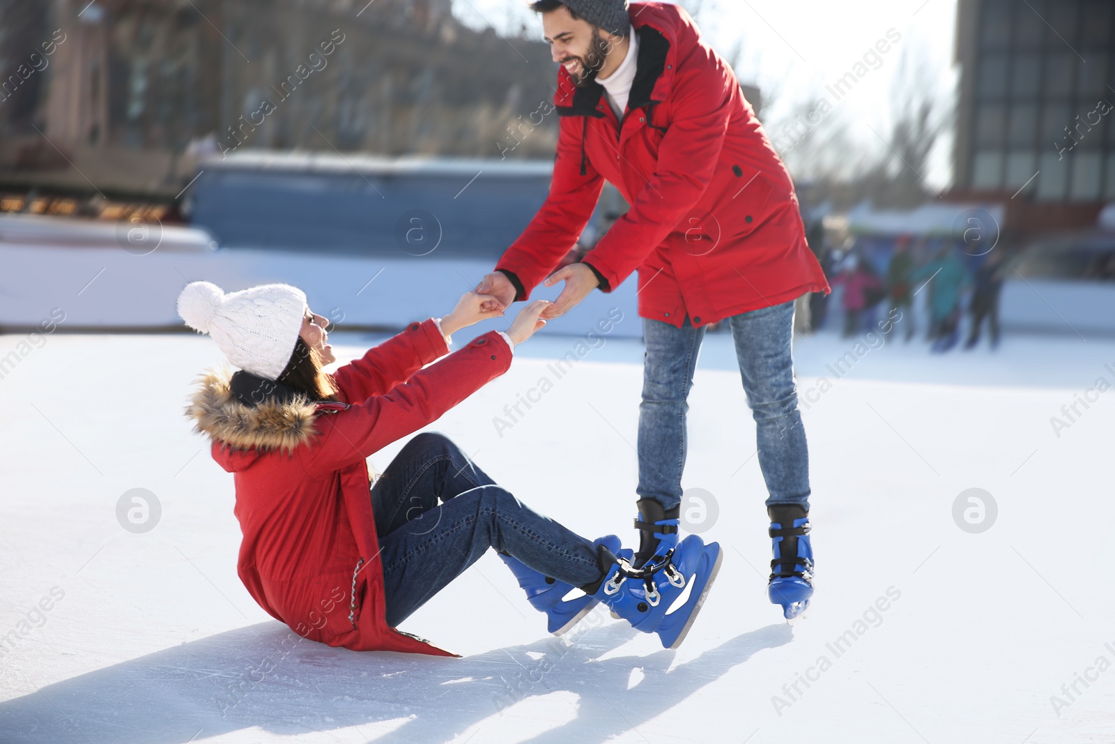 Image of Lovely couple spending time together at outdoor ice skating rink