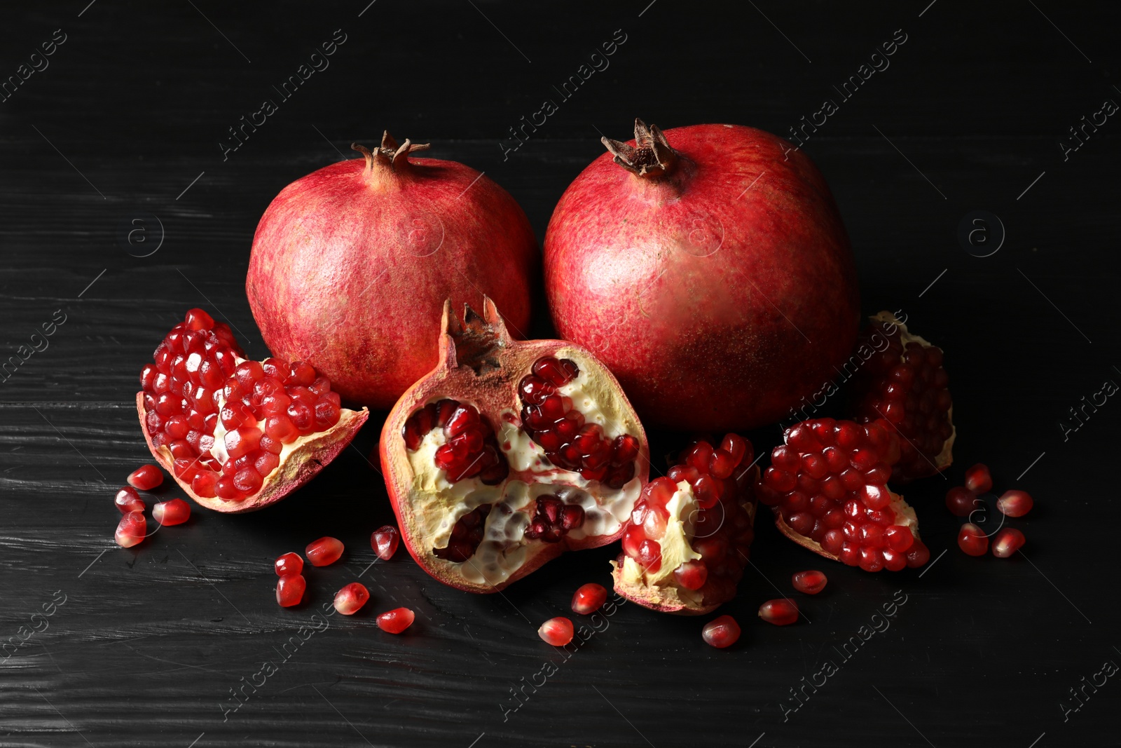 Photo of Ripe red pomegranate fruits on dark background