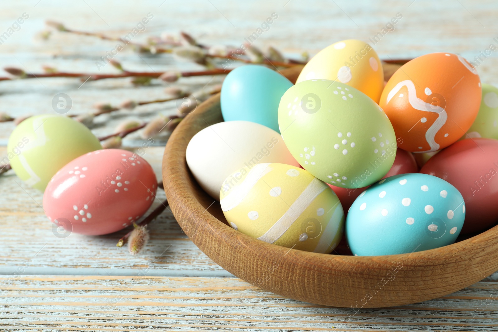 Photo of Plate with painted Easter eggs on wooden table