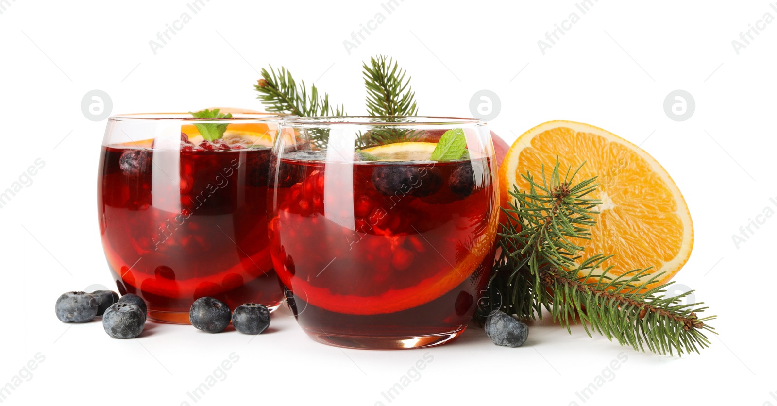 Photo of Aromatic Christmas Sangria drink in glasses, fir branches and ingredients isolated on white