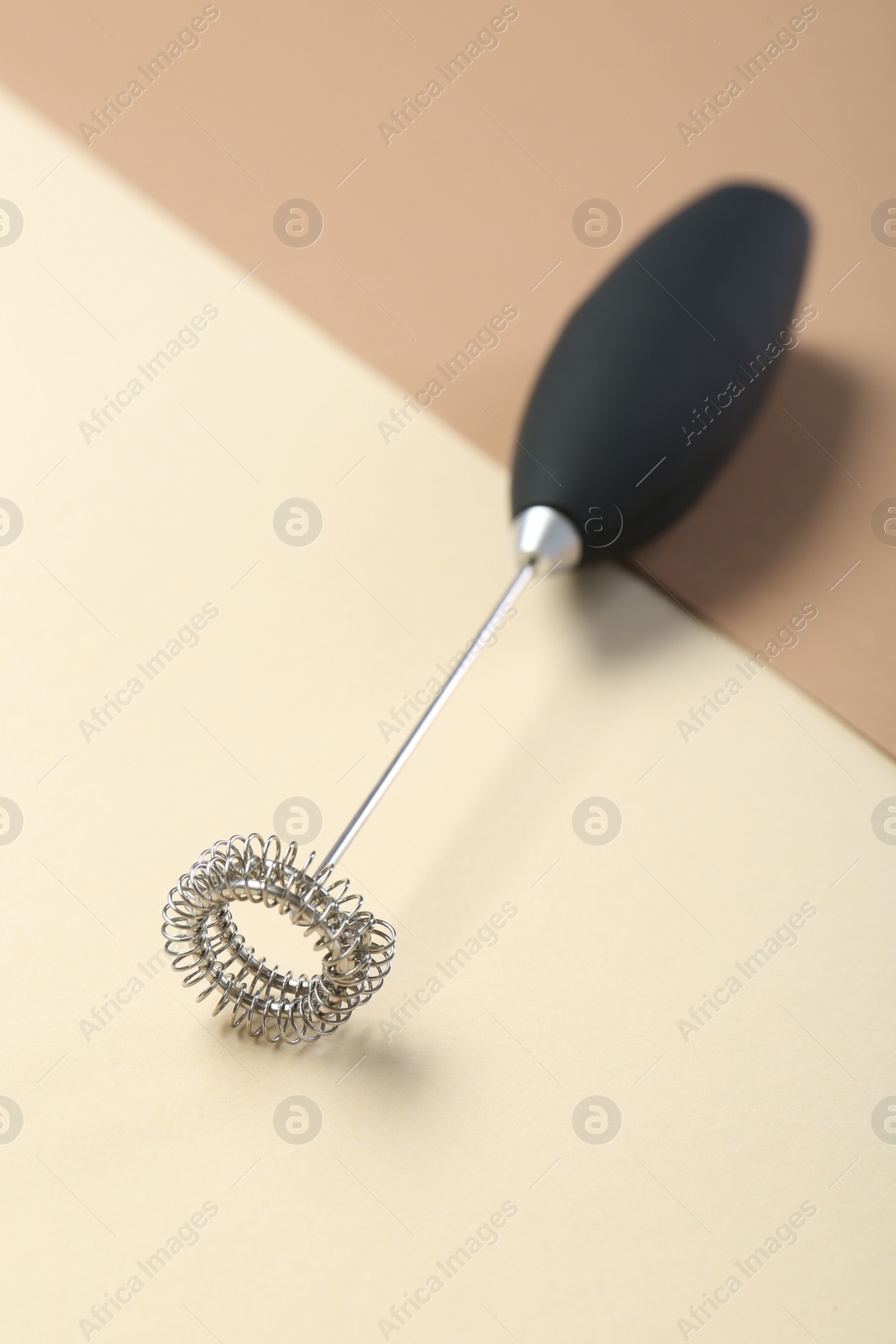 Photo of Black milk frother wand on color background, closeup