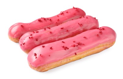 Photo of Delicious eclairs covered with pink glaze isolated on white