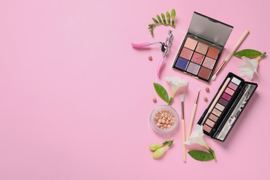Photo of Flat lay composition with eyeshadow palettes and beautiful flowers on pink background, space for text