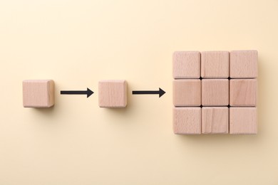 Photo of Business process organization and optimization. Scheme with wooden figures and arrows on beige background, top view