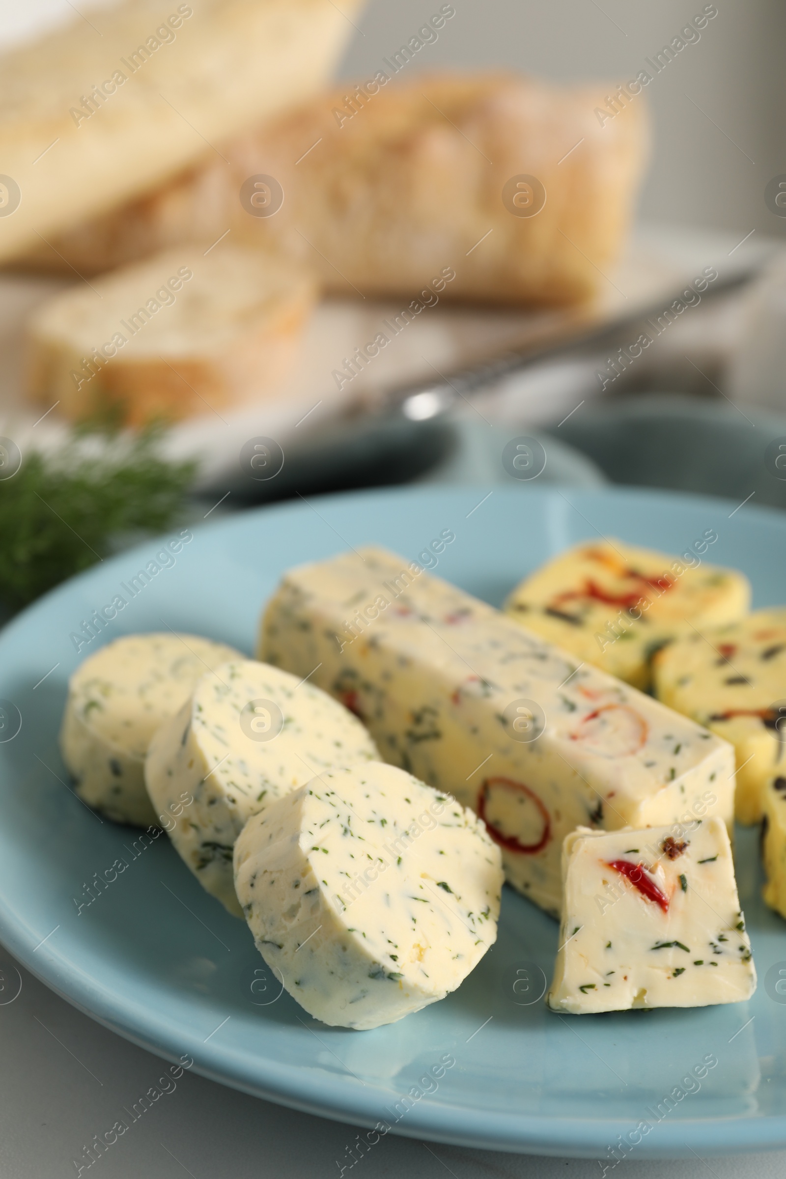 Photo of Tasty butter with herbs and spices on white table, closeup