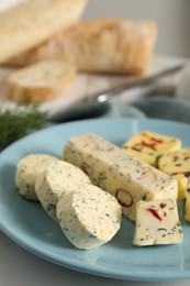 Photo of Tasty butter with herbs and spices on white table, closeup