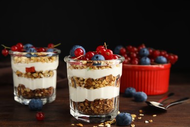 Photo of Delicious yogurt parfait with fresh berries on wooden table
