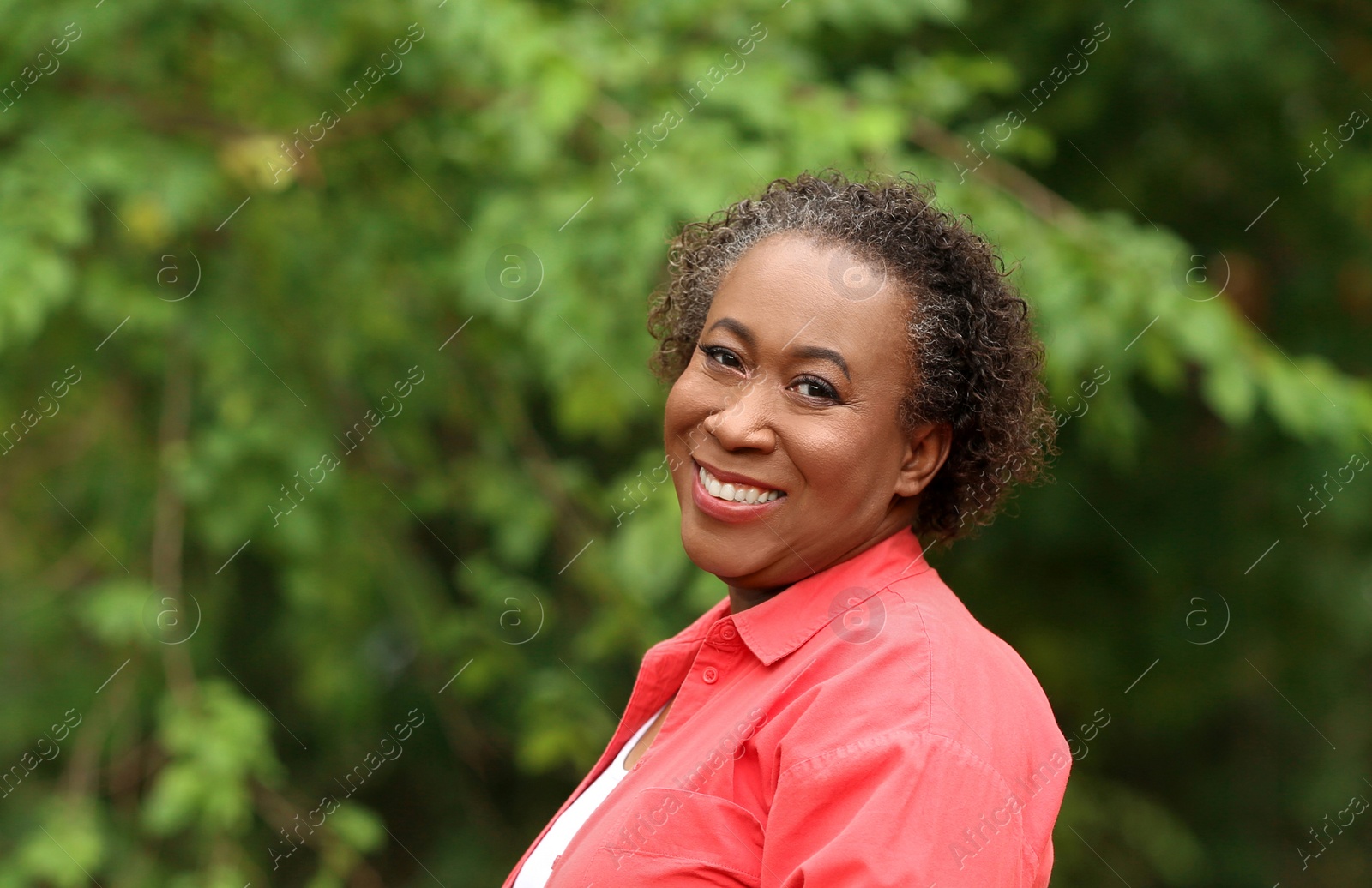 Photo of Portrait of happy African-American woman in park