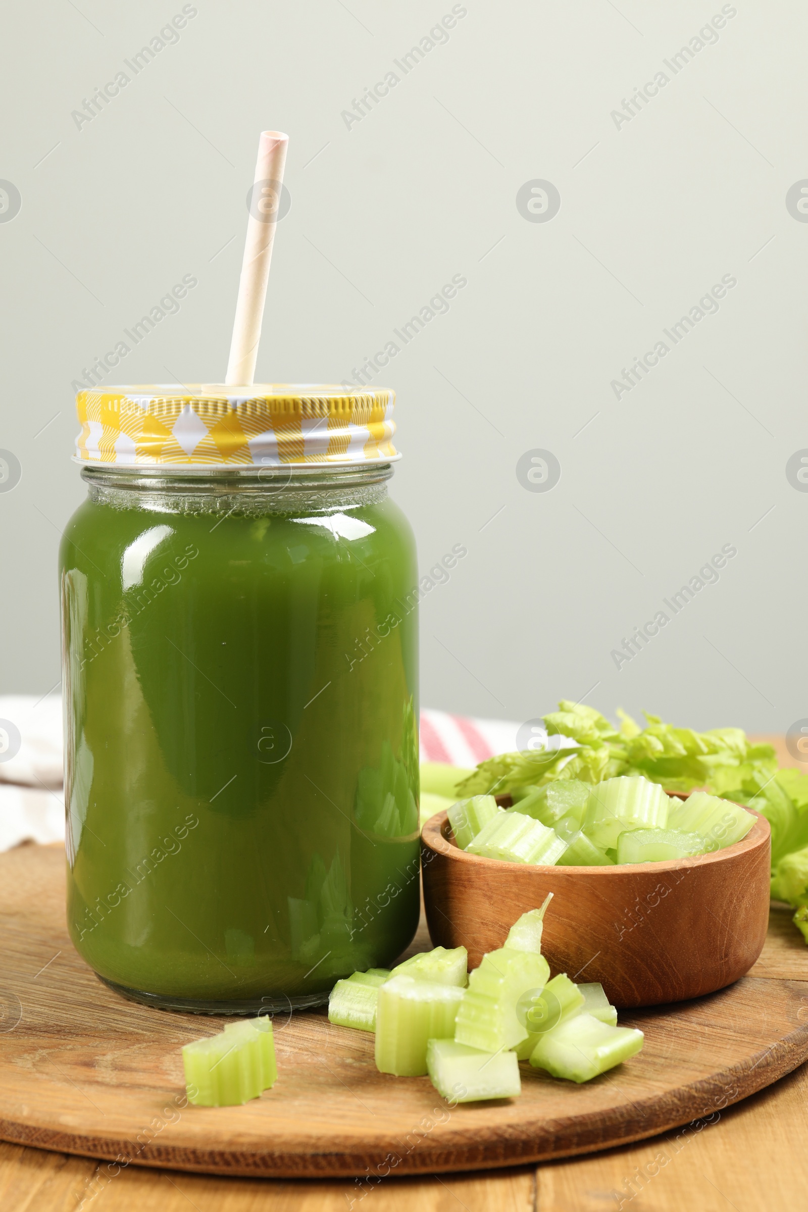 Photo of Celery juice in mason jar and fresh vegetable on table