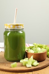 Photo of Celery juice in mason jar and fresh vegetable on table