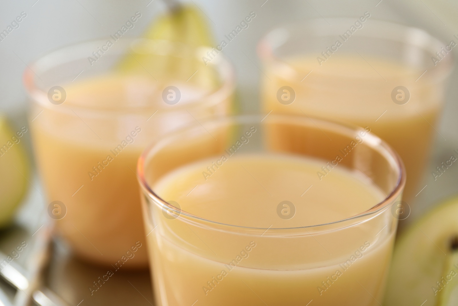 Photo of Glasses of tasty fresh pear juice, closeup