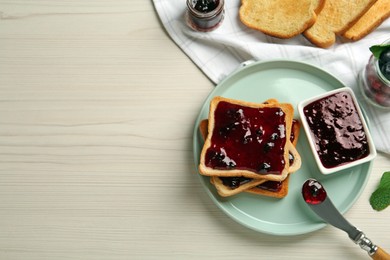 Photo of Delicious toasts with jam served on white wooden table, flat lay. Space for text