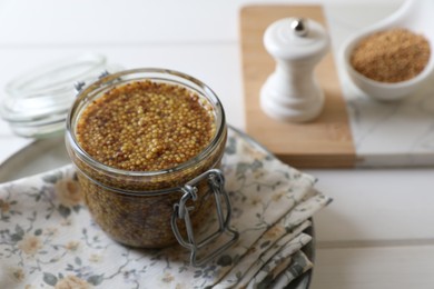 Photo of Jar of whole grain mustard on white wooden table. Space for text