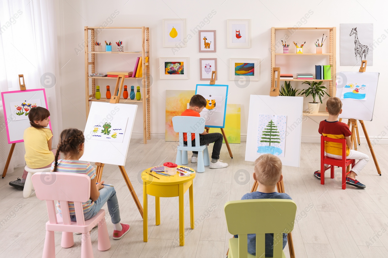 Photo of Little children painting during lesson in room