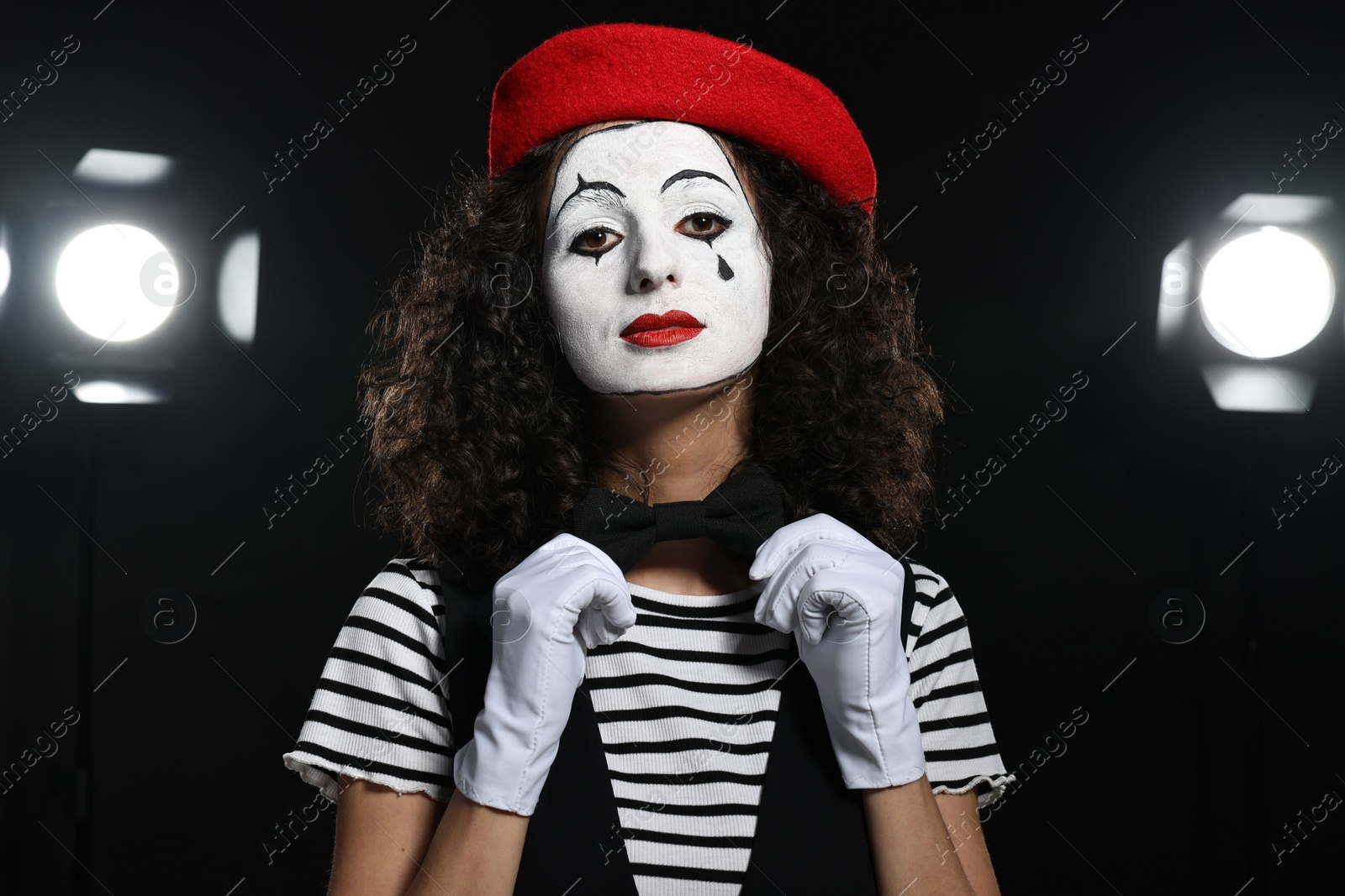 Photo of Young woman in mime costume performing on stage