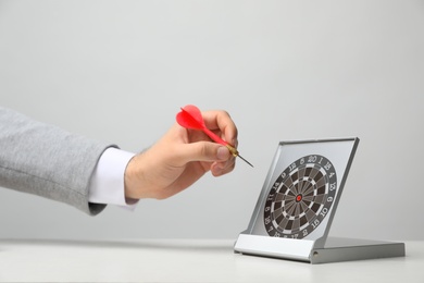 Photo of Man with darts at table. Business trainer concept